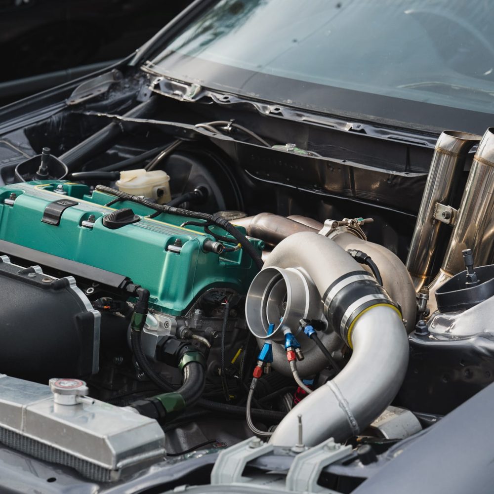 Close-up view of modified car engine, vibrant green valve cover, turbocharger, and intricate piping Ideal for automotive enthusiasts and performance vehicle projects Close-up view of modified car engine, vibrant green valve cover, turbocharger, and intricate piping Ideal for automotive enthusiasts and performance vehicle projects