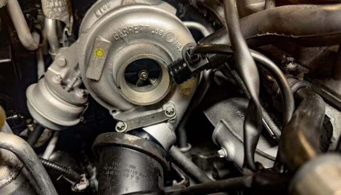 Garrett turbocharger installed on car engine enhancing performan Ferrara, Italy 18 December 2024: Close-up of a garrett turbocharger integrated into a modern car engine, boosting power and efficiency